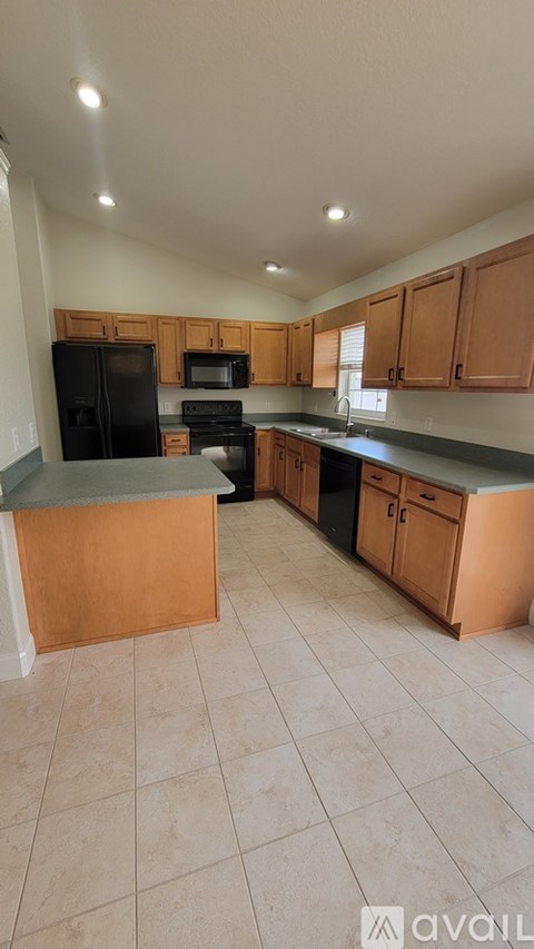 A kitchen with wooden cabinets and black appliances.