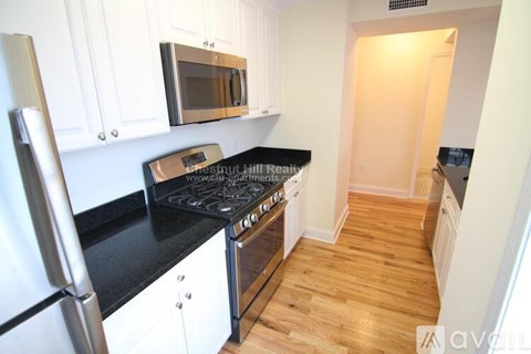 A kitchen with a stove top oven and a refrigerator.