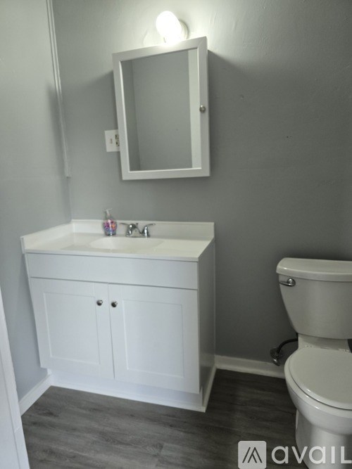 A bathroom with a white sink and toilet.