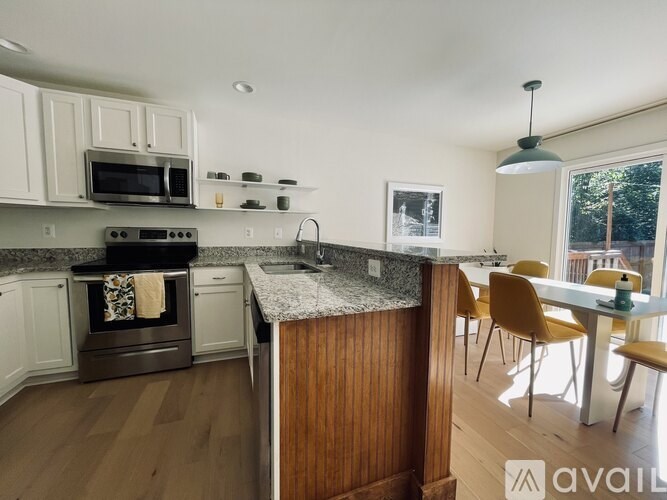 A kitchen with a wooden island and a dining table with chairs.