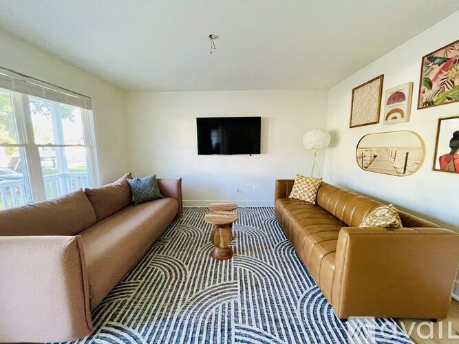 A living room with a striped carpet and a television.