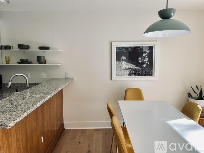 A kitchen with a marble countertop and wooden cabinets.