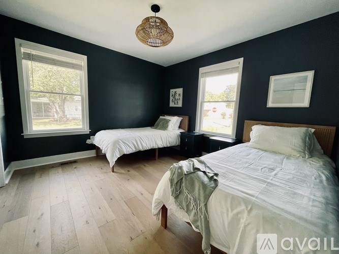 A bedroom with two beds and a window.