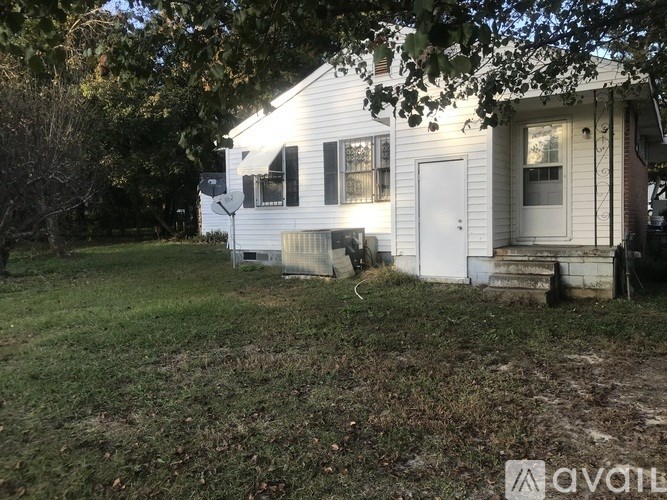 A white house with a tree in front of it.