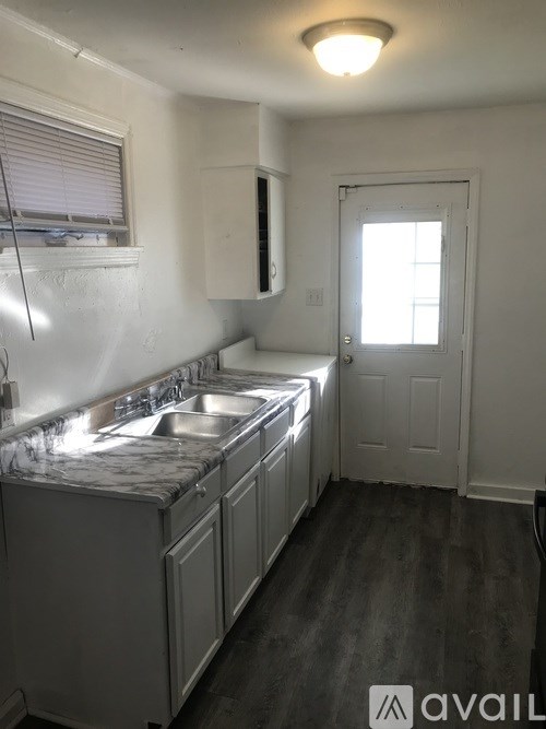 A kitchen with a marble countertop and white cabinets.