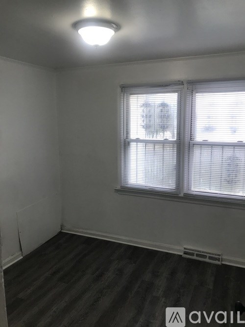 A room with a window and a wooden floor.