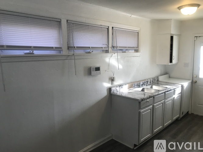 A white kitchen with a sink and cabinets.
