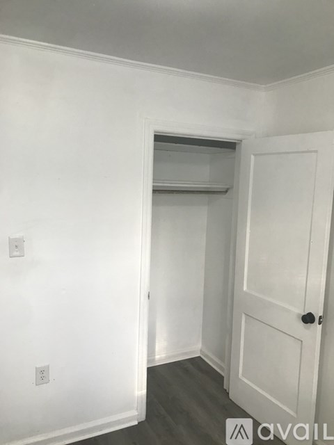 A white door is on the right side of a room with a window above it.
