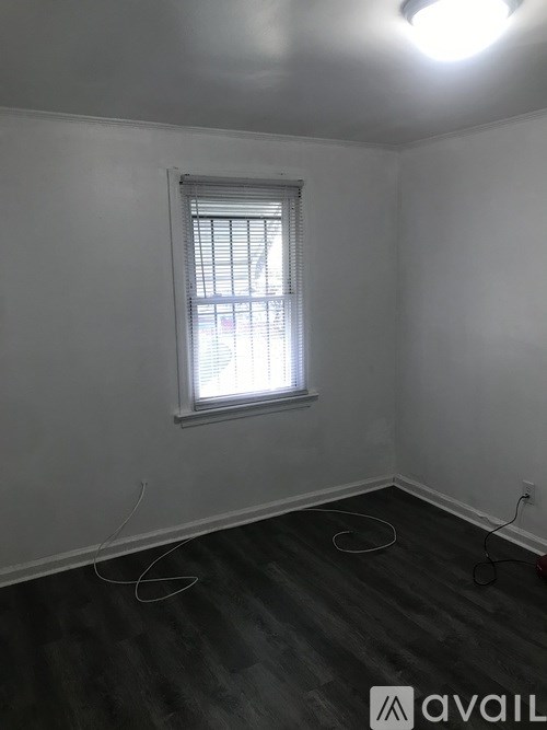 A room with a window and wooden flooring.