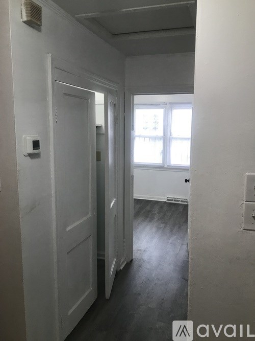 A hallway with white doors and a window.
