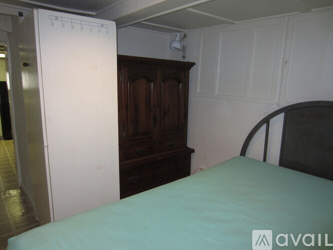 A bedroom with a bed, wardrobe and a white door.