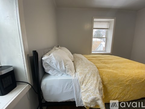 A bedroom with a bed, rug, and fan.