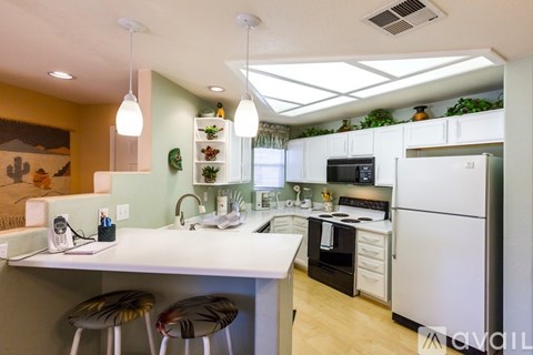A kitchen with a white counter and a white fridge.