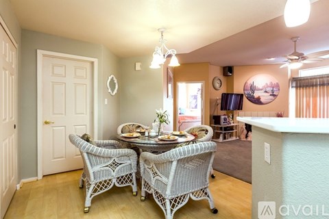 A dining room with a table set for two and chairs with a white pattern.