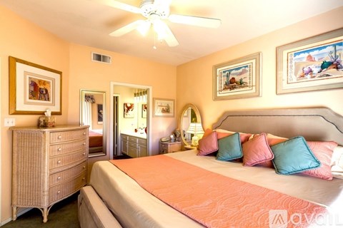 A bedroom with a bed, dresser, and ceiling fan.