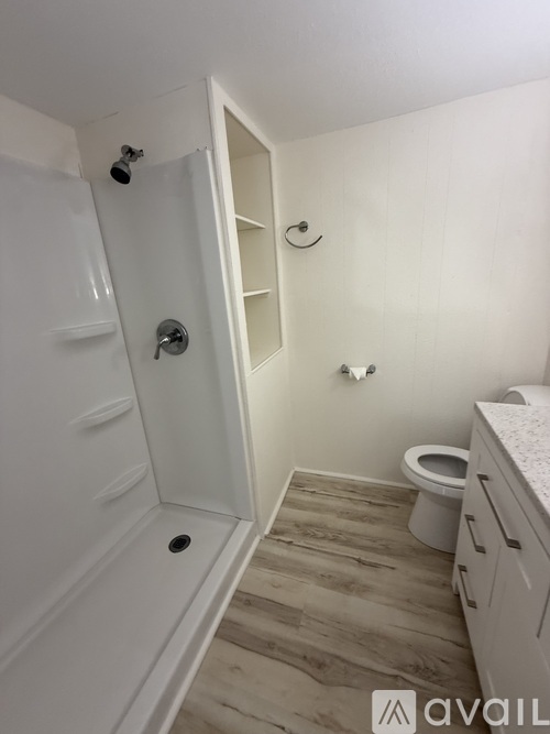 A hallway with wooden floors and white walls.