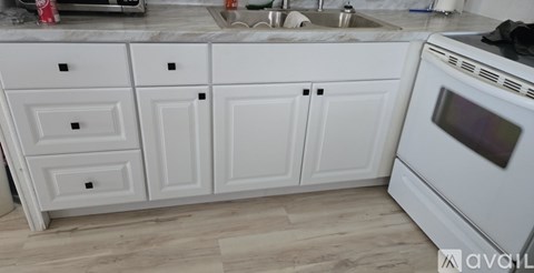 A kitchen with white cabinets and a white oven.