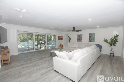 A living room with a white couch and a ceiling fan.