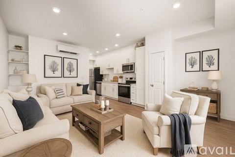 A spacious room with wooden flooring and white walls.