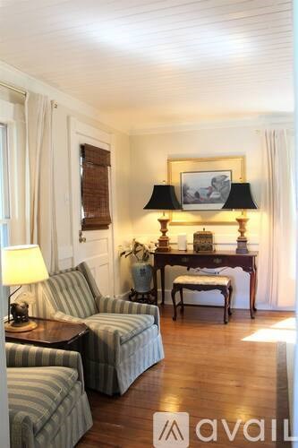 A living room with a striped couch and a wooden table.