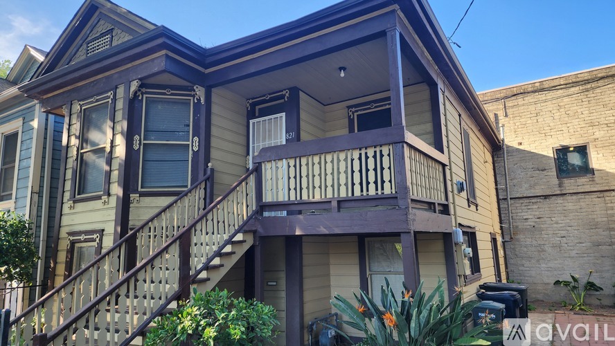 A two-story house with a balcony and stairs leading to the second floor.