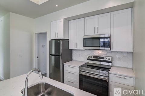 A kitchen with white cabinets and stainless steel appliances.