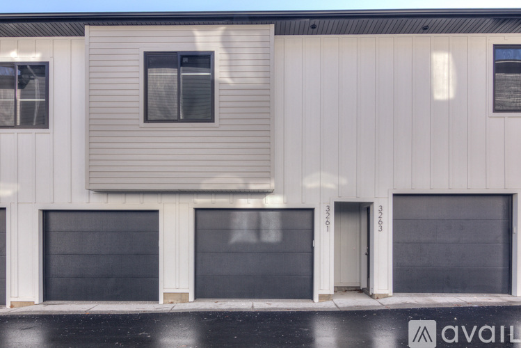 A building with three garage doors and two windows.