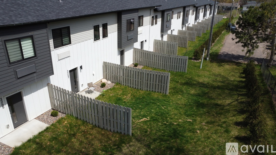 A row of houses with a fence in front of them.