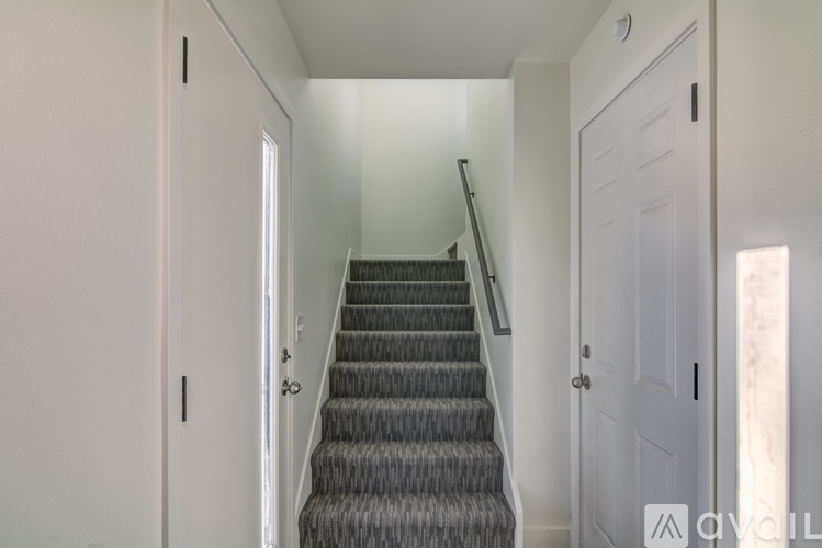 A staircase with a carpeted runner and white walls.