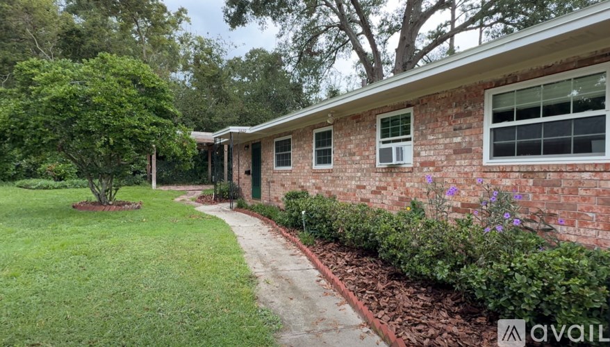 A brick house with a green bush in front of it.