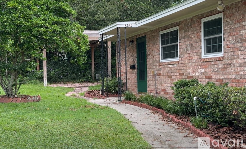 A brick house with a green door and windows.