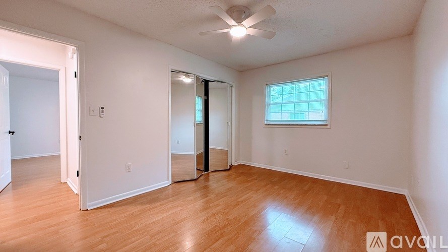 A room with a wooden floor and a ceiling fan.