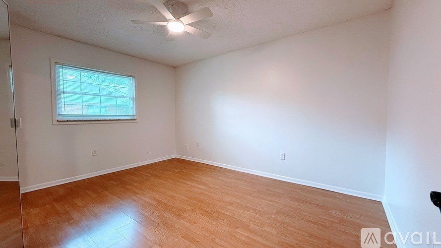 A room with a window and a ceiling fan.