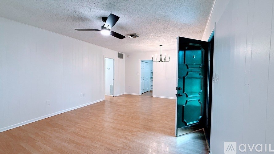 A room with a ceiling fan and a chandelier.