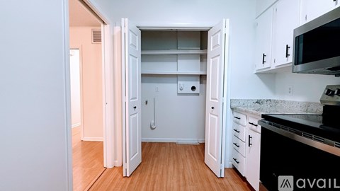 A kitchen with white cabinets and a black countertop.