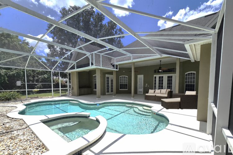 A modern house with a pool and a covered patio.