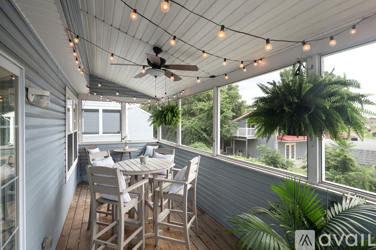 A patio with a table and chairs and a ceiling fan.