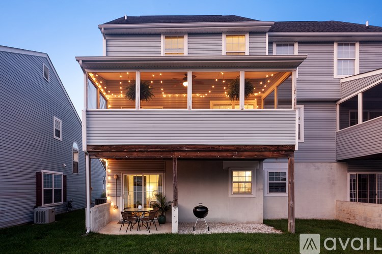 A house with a lit up balcony and a grill on the patio.