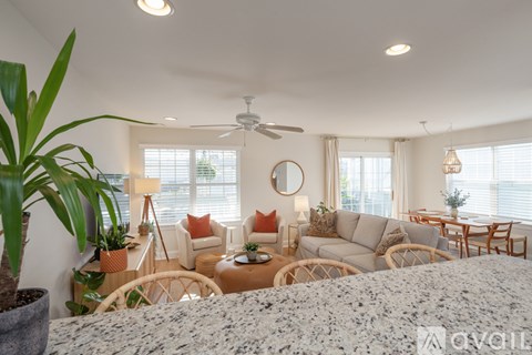 A living room with a grey sofa set and a large window.