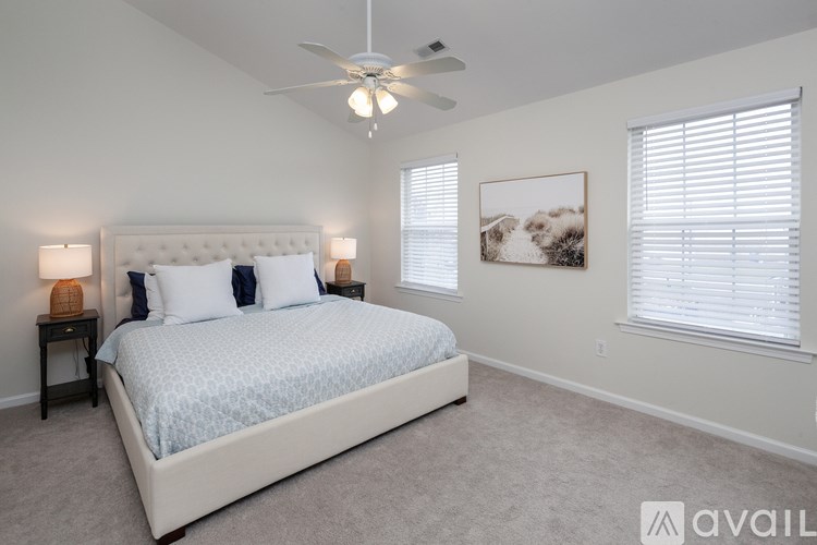 A bedroom with a large bed and a ceiling fan.