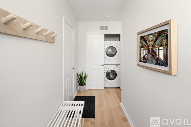 A hallway with a washing machine and a painting on the wall.