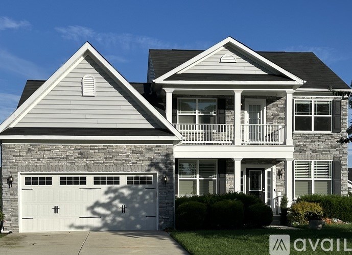 A two-story house with a garage is available for sale.