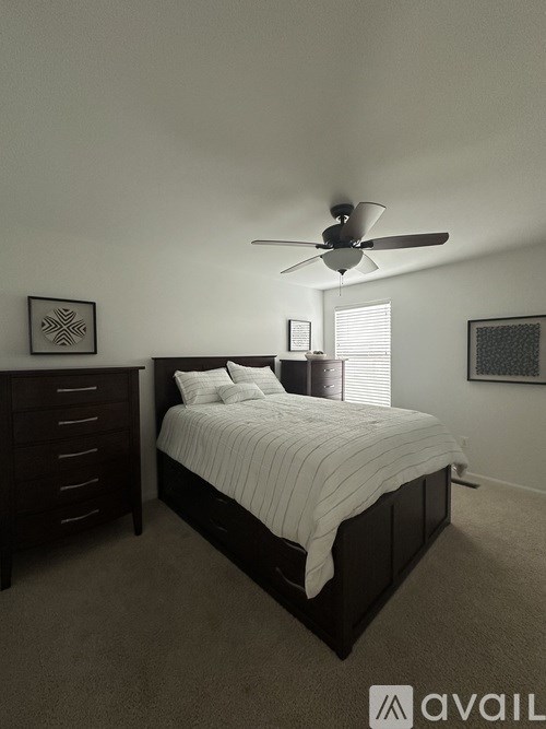 A bedroom with a bed, dresser, and ceiling fan.