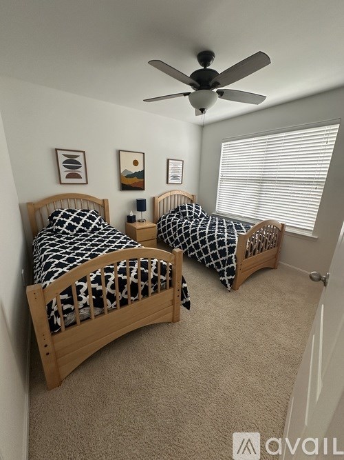 A bedroom with two beds and a ceiling fan.