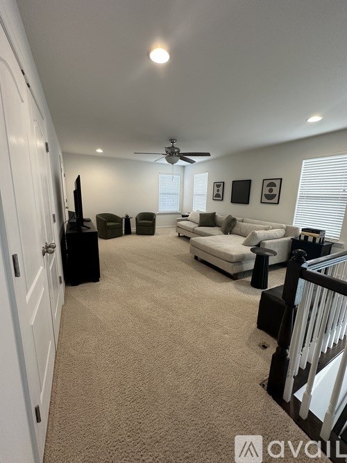 A living room with a white couch and a television.