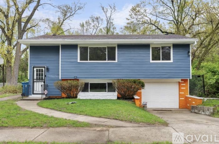 A blue house with a white garage door and a white door.
