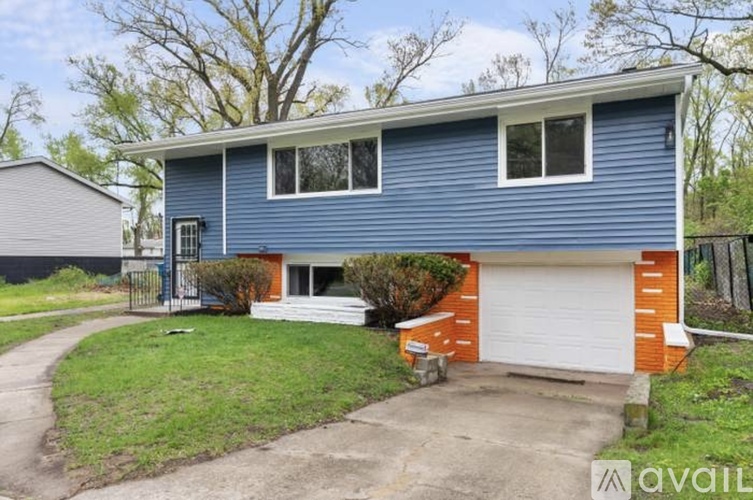A blue house with a white garage door is for sale.