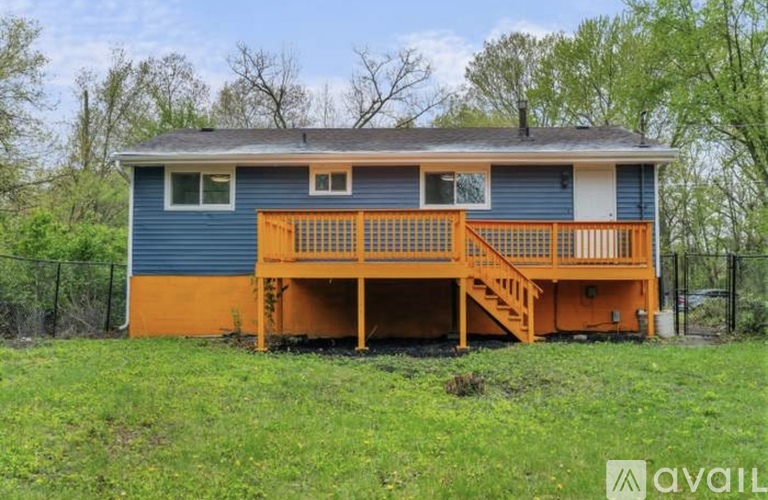 A blue house with an orange deck and stairs.