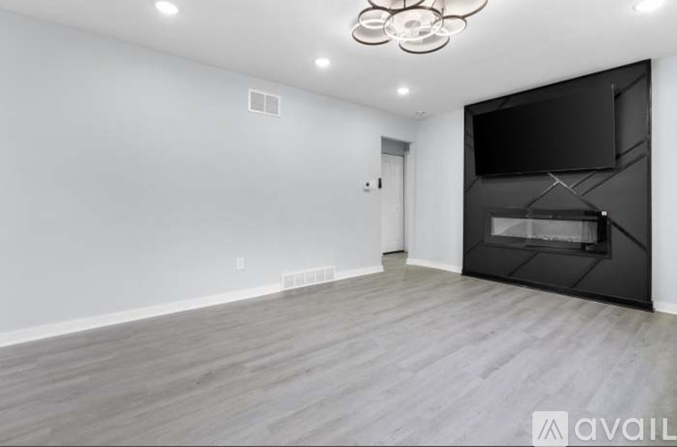 A spacious room with a fireplace and a television.