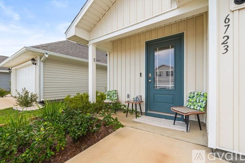 A house numbered 6723 has a blue door and a small garden in front.